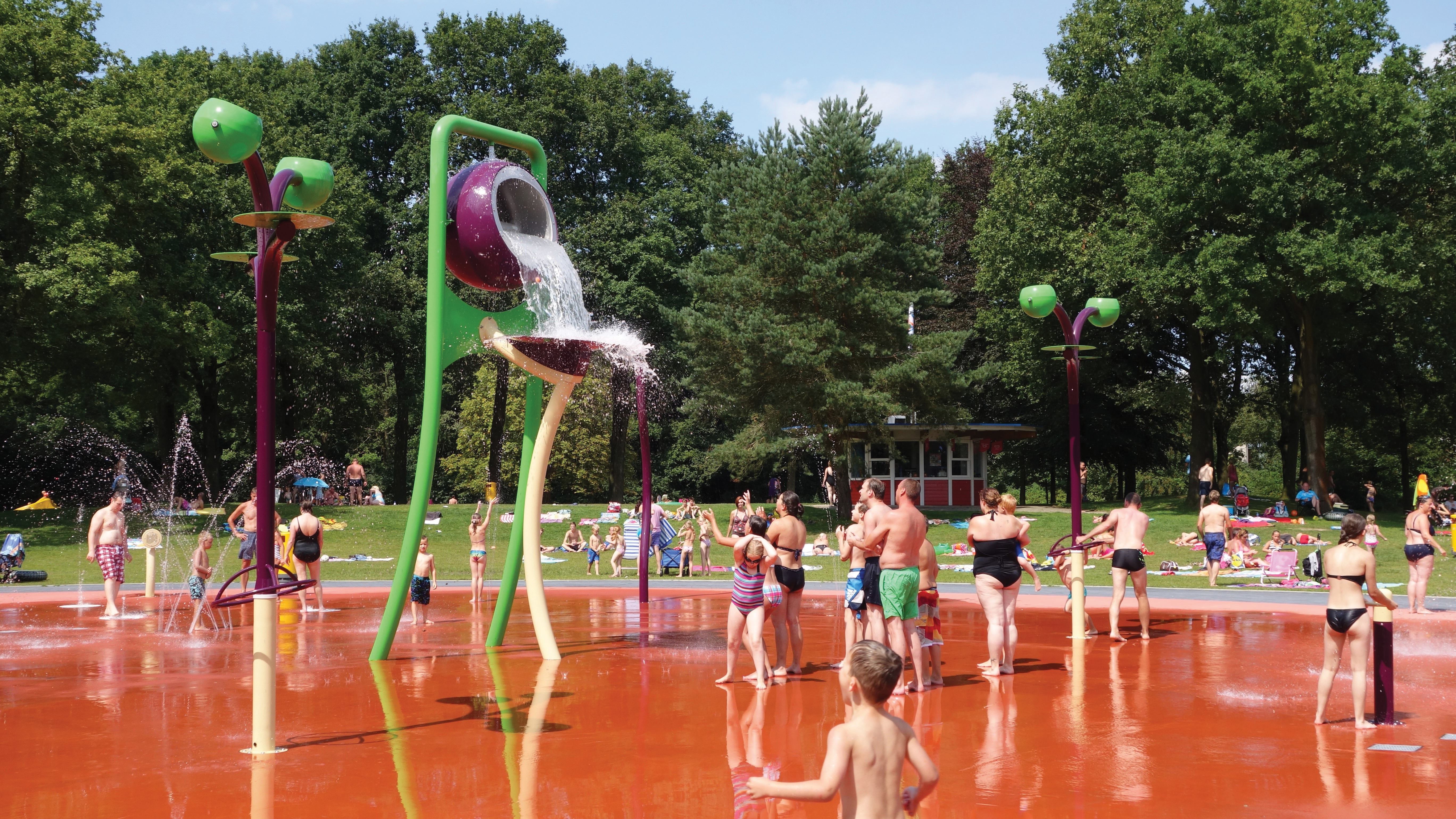 The spraypads are connected by a path and common materials, lines and colors. Light and dark greens project the look of grasses in various stages of growth, while blues, yellows, reds and plums draw attention.