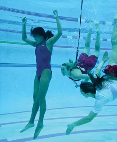 Two rescuers work together to retrieve a victim in deep water.