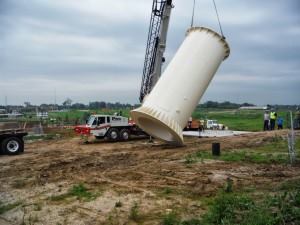 The first section of the steel tower, weighing 35,000 pounds, is lifted to be set in place.