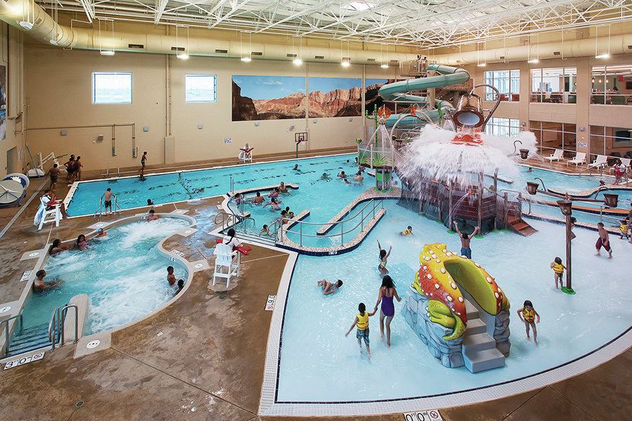 Construction of the center took two years, during which time an existing facility needed to remain operational. To accomplish this, the team incorporated a “wrap concept,” whereby the new building was designed to wrap around the existing one. This created one problem: Because of setback requirements, the new building encroached on one side of an existing gymnasium. The team removed one end of the old gym and installed a temporary wall, which allowed programming to continue. This also reduced costs, by removing the need for a temporary facilitiy. With the new building complete, the old facility was demolished and the space used for entry drop-off and parking.