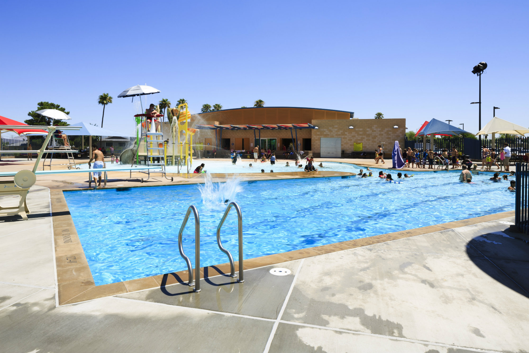 For the exercise-minded: Set in the middle of the three pools, and connected to the others on each side, the lap pool sports four dedicated lanes and a 1-meter diving board. This pool ranges in depth from 3-1/2 to 12-1/2 feet for diving. Not pictured, the designers incorporated a modified open-air concept for the locker rooms that limits the amount of dirt and debris that are carried in, thus reducing maintenance and janitorial costs. Operators sought to reduce energy usage, so energy-saving light bulbs and fixtures are placed throughout the area. A multi-staged pumping system is meant to lower environmental impact and utility costs. In the future, management may add solar-thermal panels in the parking area.