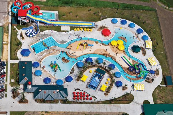 Completed in May 2010, Pirate’s Bay incorporates numerous amenities on a relatively small footprint. The space features 349,800 square feet of aquatic space, including a 25-yard lap/fitness pool; two pirate-themed children’s play features; a pirate-themed crossing activity; a 670-foot-long lazy river, a FlowRider stationary wave machine; a bowl slide; a four-lane mat racer slide; two body flume water slides; two raft water slides; a climbing wall; a wet deck with bubblers; spraying palms and pirate-themed features; shallow-water leisure pool space; and kiddie slides. 