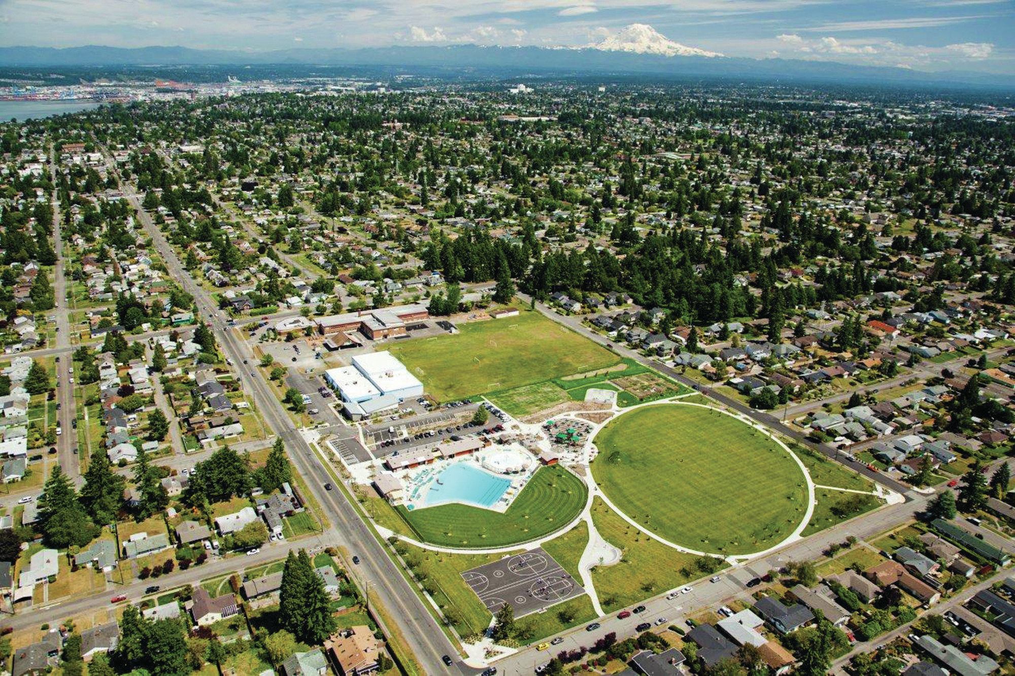 Despite a 9-foot elevation change on the site, minimal grading was needed due to careful placement of the pool. A chamber holding the wave-generating equipment was tucked below a viewing platform at grade, which ramps down to the pool’s zero-depth entry. Because the facility is located on a busy street, the designers placed support buildings and landscaping to shield patrons from traffic and parking.