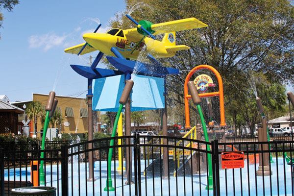 Some spraypark elements are

aquatic-themed in nature, further tying the project into the

waterfront Wooten Park location on Lake Dora. The deck of the

splash pad was designed to look like water, with alligator and fish

head spray features. It has multicolored Tuffcoat nonslip coating,

for aesthetic and safety reasons.
