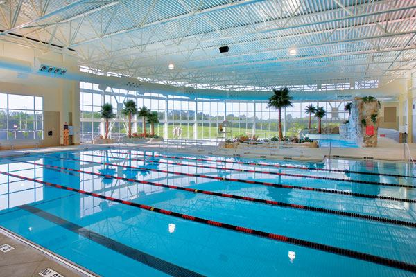 For lap swimming, the facility includes a 6-lane-by-25-yard lap pool. There’s also a 12-person whirlpool spa, men’s and women’s locker facilities, on-deck steam and sauna rooms, administrative and lifeguard offices, an aquatic multi-purpose room, a first-aid office, and storage space. The tropical-theme facility was planned with a number of sustainable design principles, including designing the site for minimal impact, specifying materials with low levels of VOC content where possible, and utilizing efficient building mechanical systems.